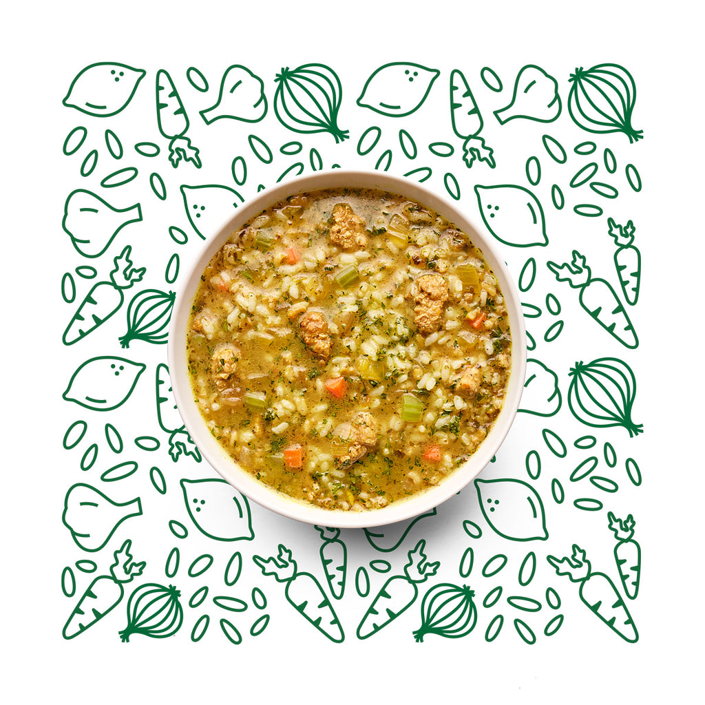 Bowl of soup sitting on illustration of vegetables. 