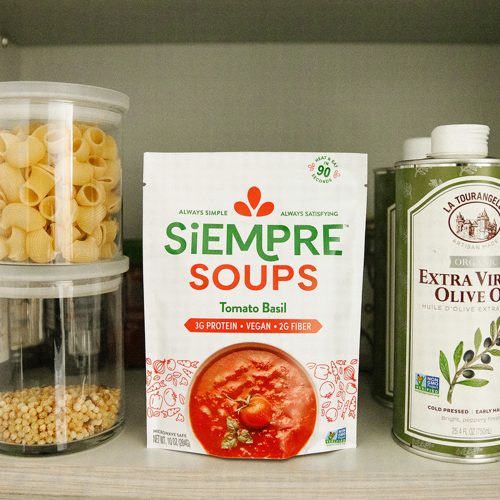 Pouch of Tomato Basil Soup on shelf next to olive oil and pasta shells.